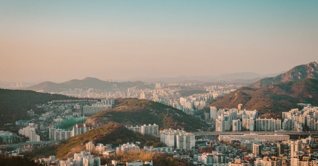 A stunning aerial view of Seoul's skyline with mountains and buildings under a clear sky.