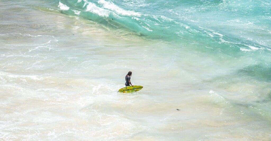 A lone surfer with a green surfboard on Bondi Beach's vibrant waves.