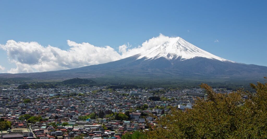 A stunning view of Mount Fuji with a clear blue sky and a town in the foreground.