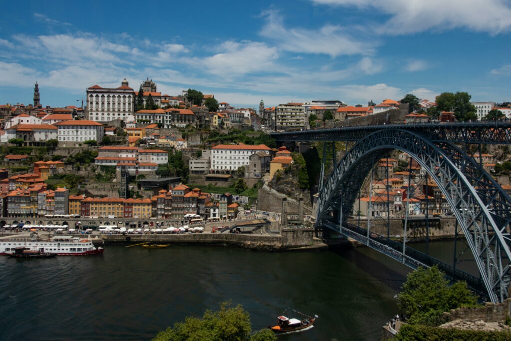 3 jours à Porto : itinéraire 🇵🇹 Scenic view of Porto, Portugal featuring the iconic Dom Luís I Bridge over the Douro River.