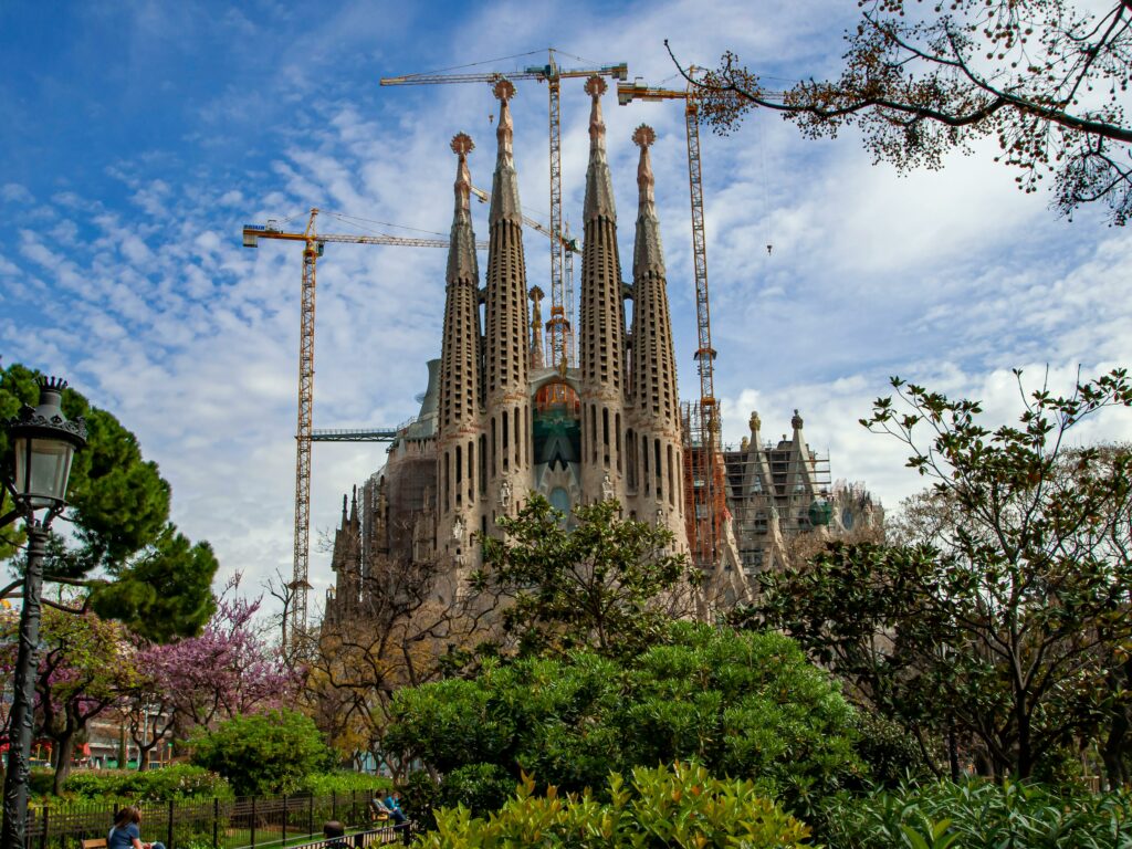 The iconic Sagrada Familia basilica surrounded by greenery, a masterpiece of Gaudí