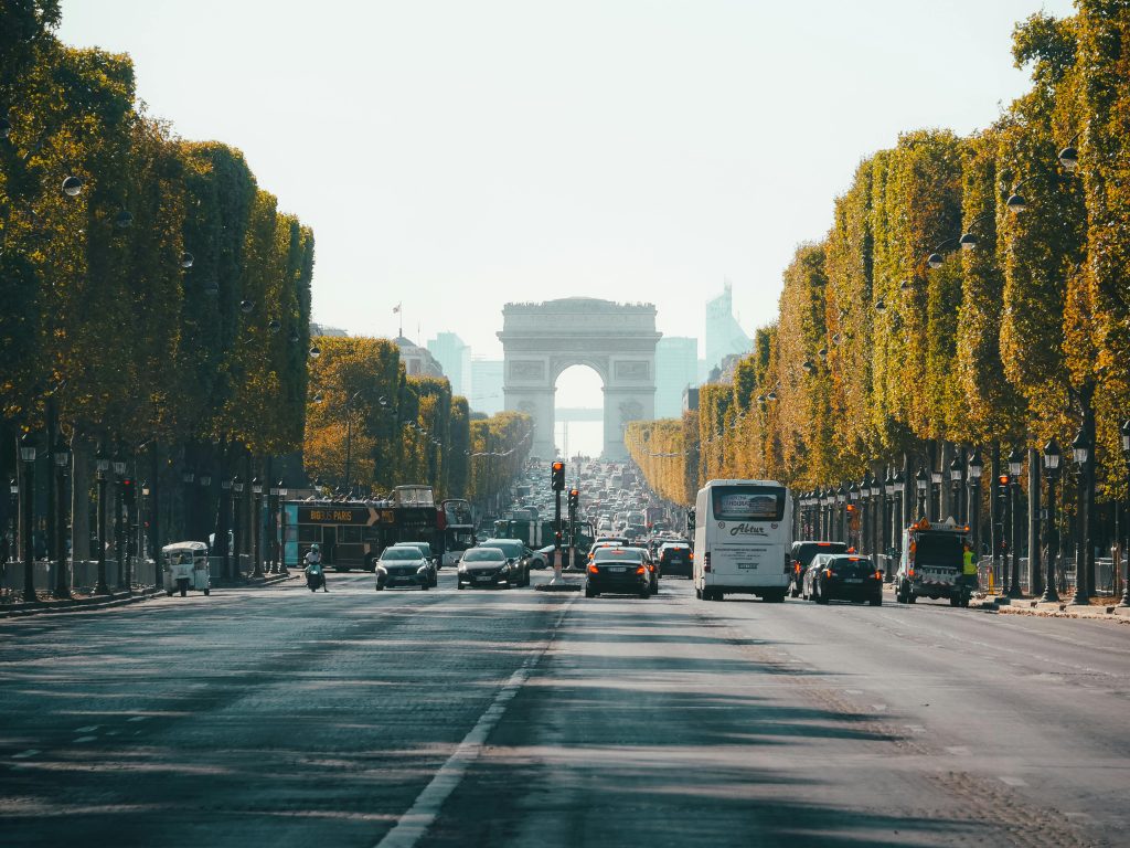 Visiter Paris en 4 jours : entre culture, gastronomie et romantisme 🇫🇷 View of the Arc de Triomphe down a busy Champs Élysées in Paris, France, during fall.