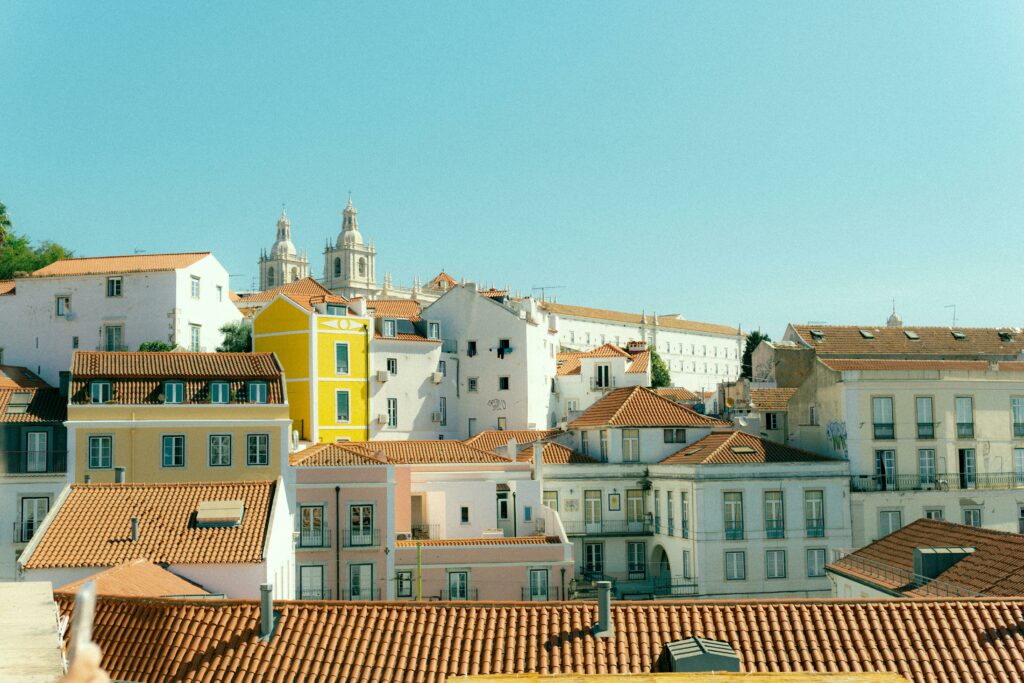 Lisbonne en 4 jours : itinéraire complet et incontournables 🇵🇹 Charming rooftops of Lisbon with a view of historic architecture on a sunny day.