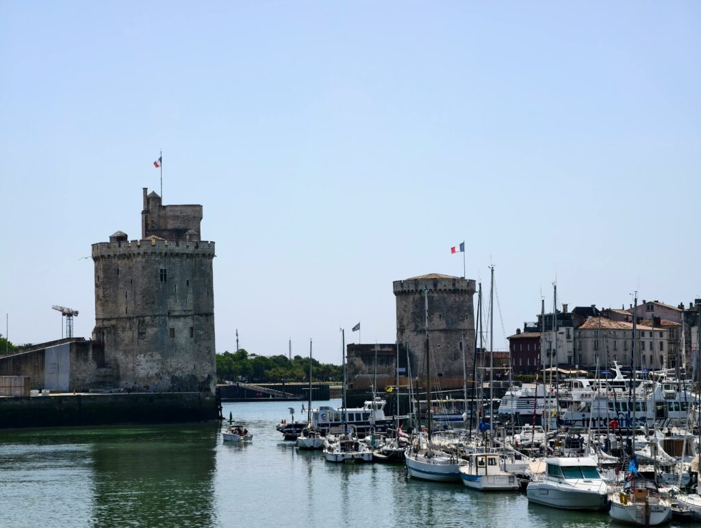La Rochelle en 3 jours : entre mer, patrimoine et douceur de vivre đ«đ· A captivating view of La Rochelle harbor with historic towers and boats under a clear sky.