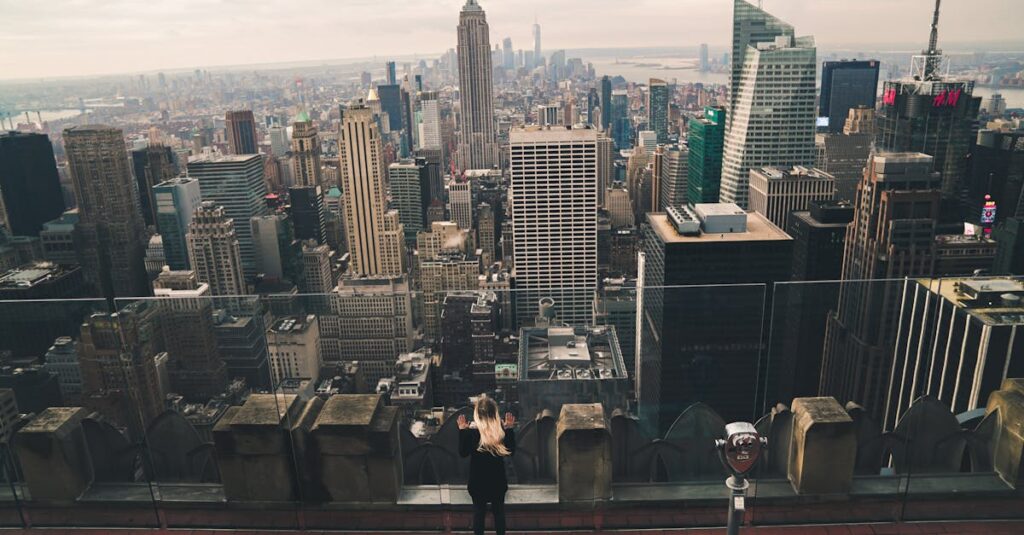 Top 5 observatoires à New York à ne pas manquer 🇺🇸 Aerial view of faceless woman looking from rooftop of building through glass at contemporary skyscrapers in downtown of New York in soft daylight